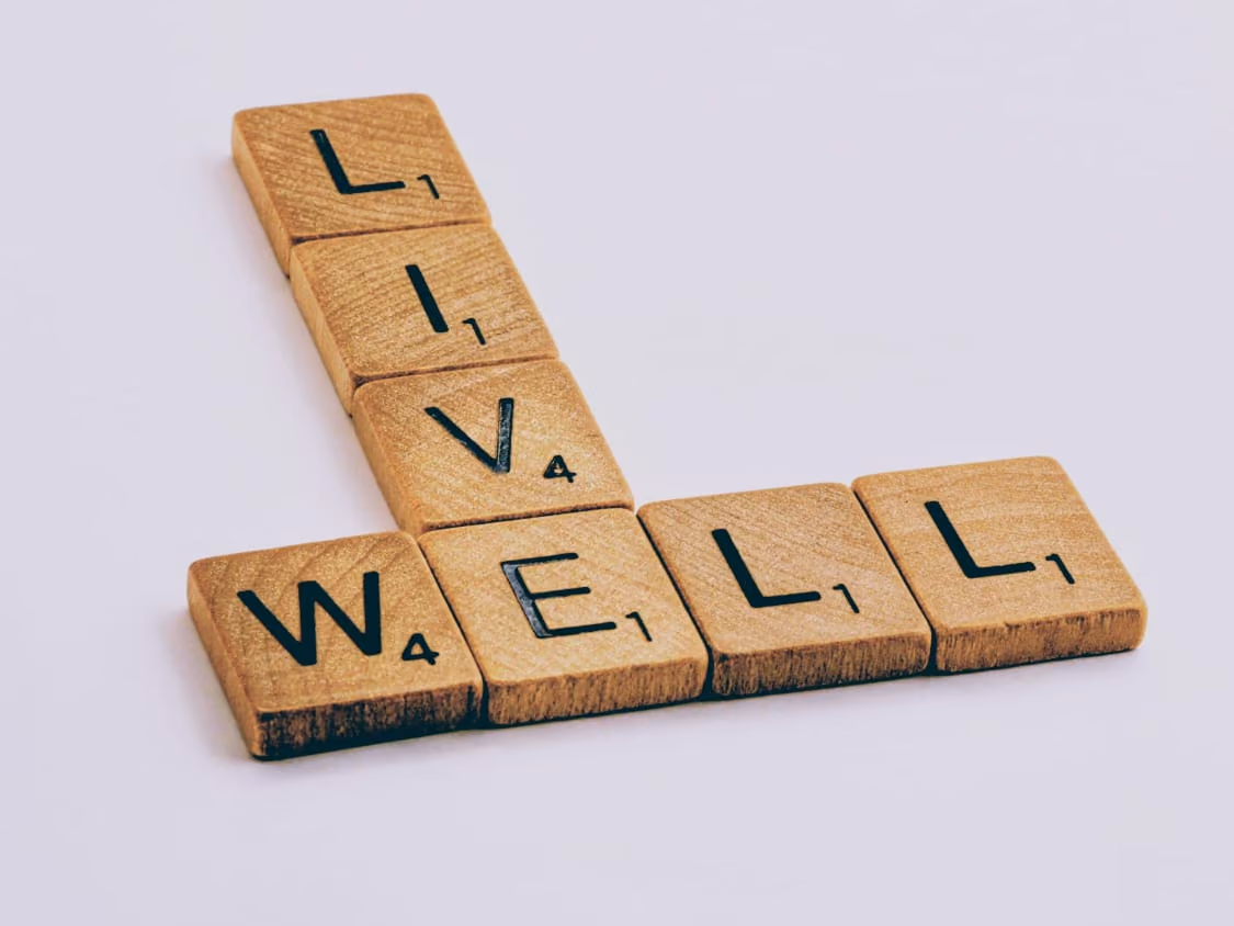 Wooden letter tiles spelling LIVE WELL